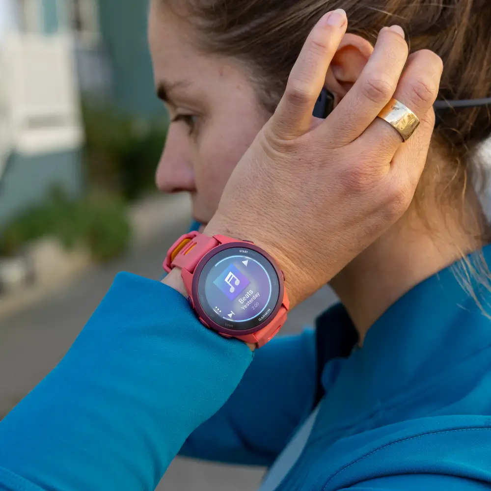 Eine Läuferin nutzt die Offline-Musikfunktion auf dem AMOLED-Display ihrer Garmin Forerunner 170 Music Laufuhr am Handgelenk