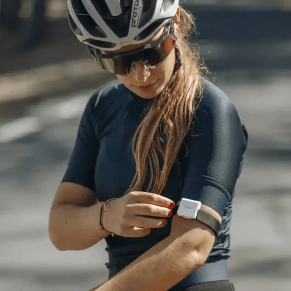 Weiblicher Ausdauersportler mit hDrop Gen 2 Hydration-Sensor am Oberarm zur Analyse von Schweißverlust und Elektrolyten