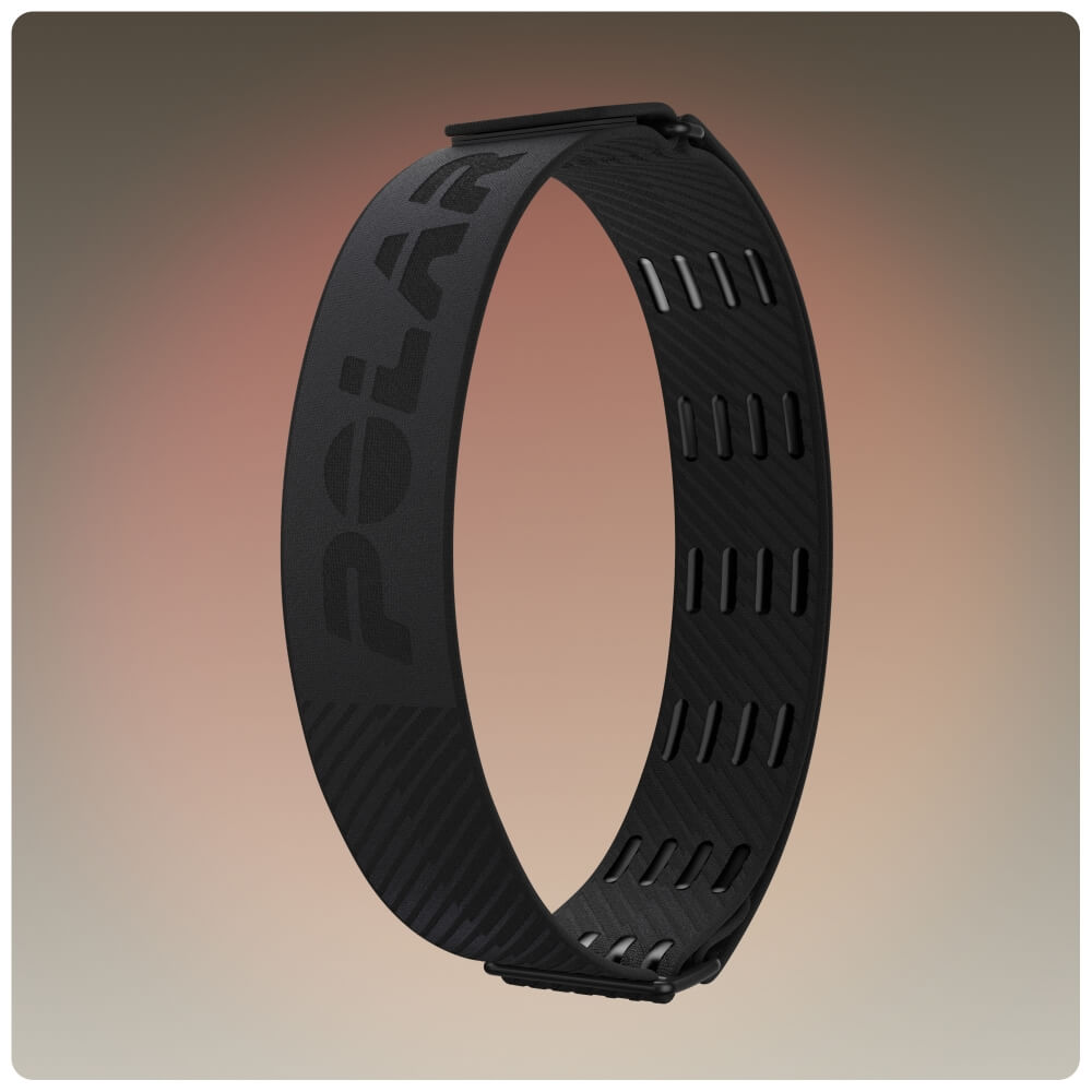 Produktbild des dunkelgrauen POLAR Loop Oberarmbands, dargestellt als geschlossene elastische Schlaufe. Zu sehen ist die Außenseite mit dem eingearbeiteten Polar-Schriftzug sowie Belüftungsöffnungen und Haken zur Größenverstellung auf der Innenseite.